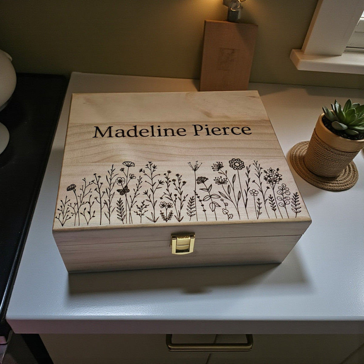 Newfashioned Relics personalized wooden keepsake box with engraved wildflower design and custom name on a white desk.