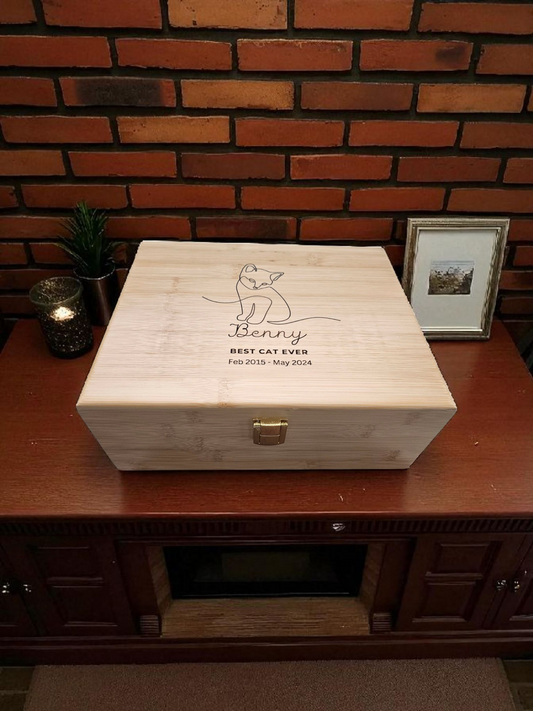 Newfashioned Relics personalized wooden cat memorial keepsake box with engraved name and dates on a wooden table.