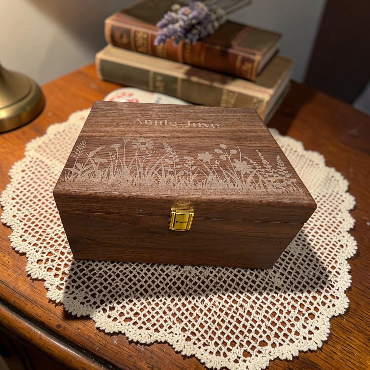 Newfashioned Relics personalized wooden keepsake box with floral engraving and gold latch on a lace doily.