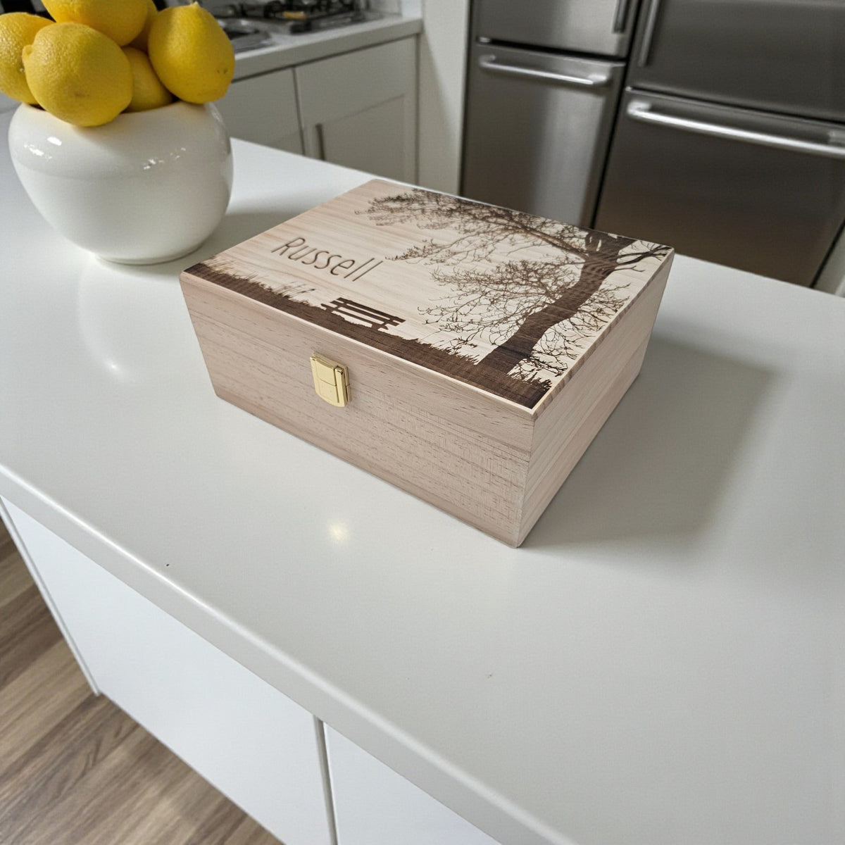 Newfashioned Relics personalized wooden keepsake box with tree and bench engraving on a white kitchen counter