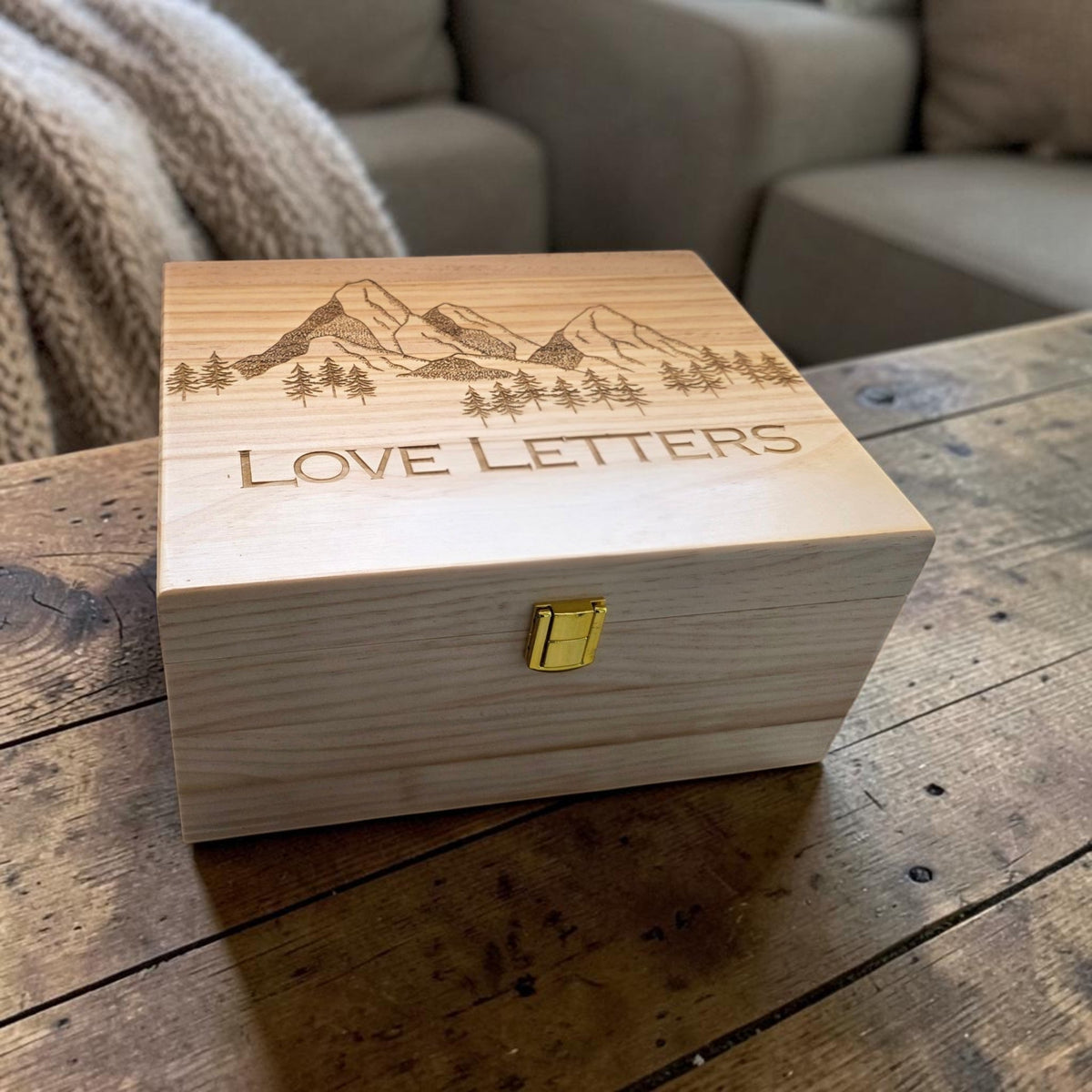 Newfashioned Relics wooden keepsake box with mountain and forest engraving and Love Letters text on a rustic table