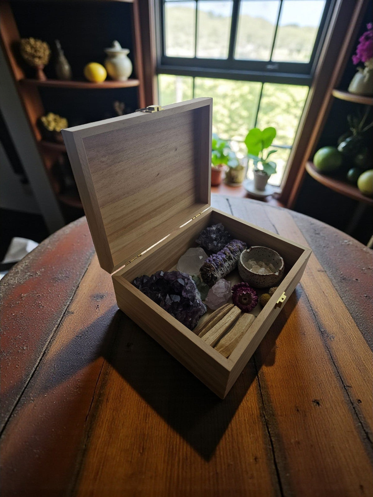 Newfashioned Relics wooden keepsake box filled with crystals, sage, and dried flowers on a rustic wooden table.
